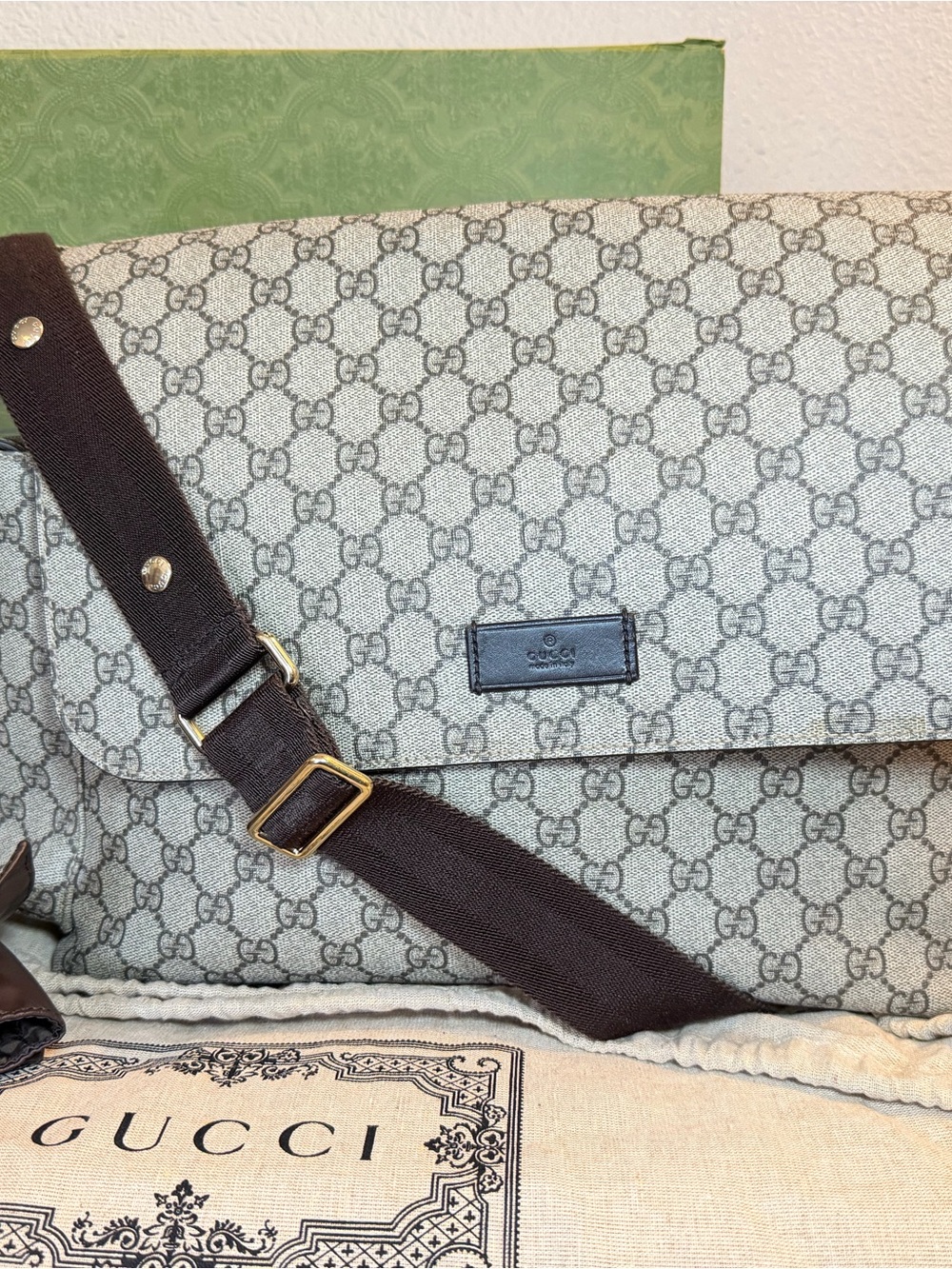 GG Supreme canvas diaper bag, designed with multiple pockets and fold-out pad